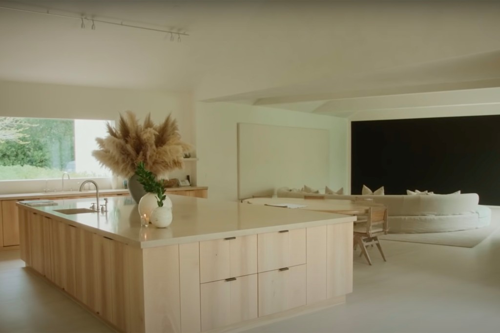 Kims beruhigende Küche!  Der Kochbereich verfügt über eine Arbeitsplatte aus weißem Marmor und Schränke aus hellem Holz.  Die Küche mit offenem Schnitt bietet Blick auf den Sitzbereich.