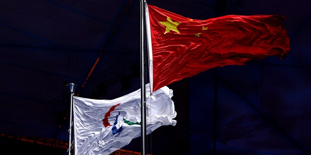 Die paralympische Flagge wird während der Eröffnungszeremonie der Olympischen Winterspiele 2022 in Peking im Nationalstadion Peking am 4. März 2022 in Peking, China, neben der chinesischen Flagge gehisst. 