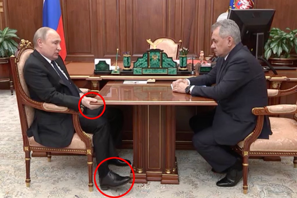 Wladimir Putin hält während eines im Fernsehen übertragenen Treffens mit seinem Verteidigungsminister aufgedunsen einen Tisch, während er auf seinem Stuhl liegt, inmitten von Gerüchten, dass der russische starke Mann gegen Krebs kämpft.
