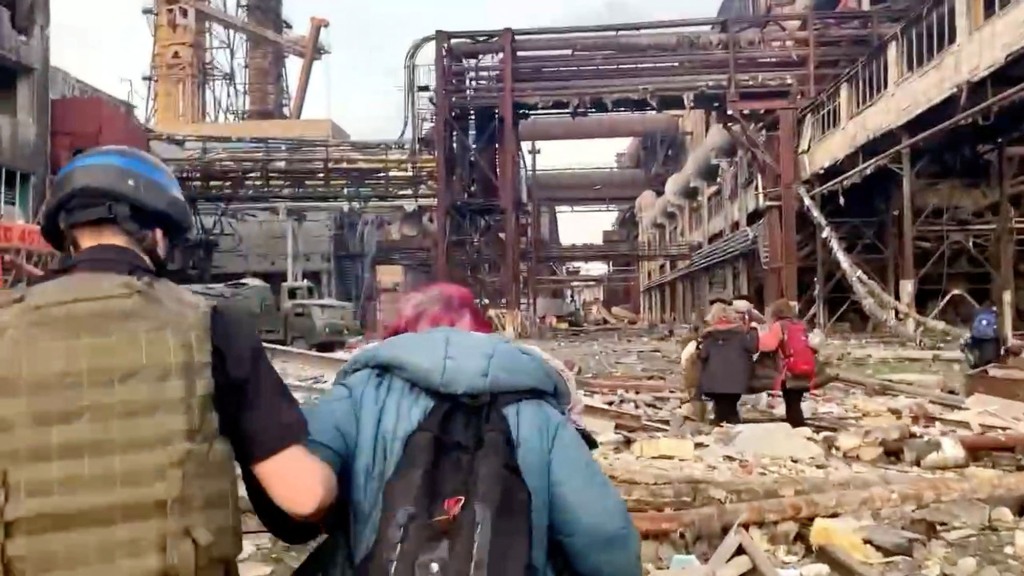 Mitglieder des Azov-Regiments gehen mit Zivilisten während UN-geführter Evakuierungen aus dem weitläufigen Azovstal-Stahlwerk, fast zwei Monate nach dem Belagerungskrieg der Stadt durch Russland während seiner Invasion, in Mariupol, Ukraine, auf diesem Standbild aus einem Beitrag, der am 1. Mai 2022 veröffentlicht wurde . 