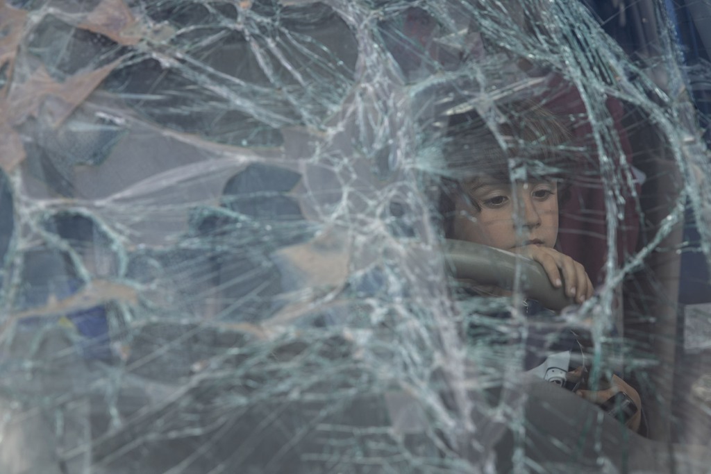 Ein Junge aus Mariupol schaut durch die zertrümmerte Windschutzscheibe des Autos seiner Familie