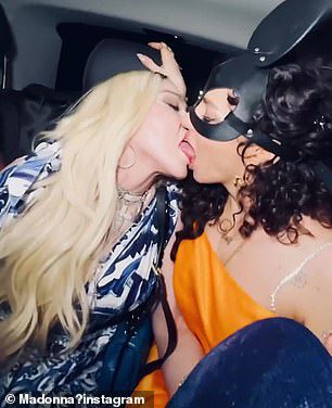 Weihnachtsumarmung: Die Pop-Queen teilte auch Fotos von sich selbst, wie sie zwei Frauen auf dem Rücksitz eines Autos mit einem Zungenkuss küsste, während sie Anfang dieses Jahres ihren 64. Geburtstag in Italien feierte