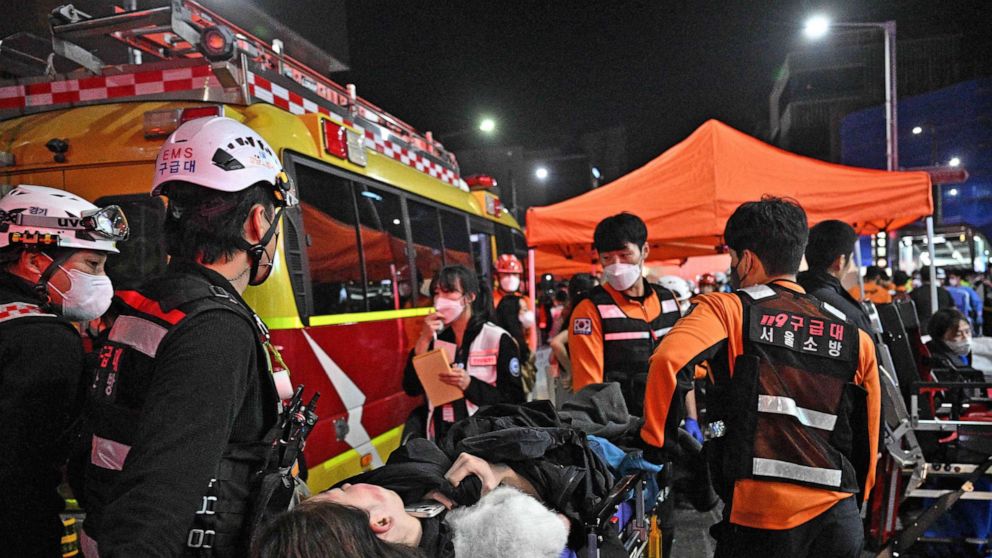 Foto: Medizinisches Personal kümmert sich um eine Person auf einer Trage, nachdem Dutzende bei einem Ansturm verletzt wurden, nachdem Menschen am 30. Oktober 2022 in Seoul, Südkorea, enge Straßen im Stadtteil Itaewon überfüllt hatten, um Halloween zu feiern.
